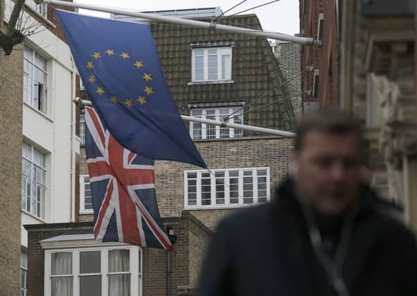 A man passes the EU flag hanging beside the Union flag at Europa House in London. The swing required to take Britain out of Europe was less than 3 per cent and it looks, at best, balanced now. Picture: AP Photo/Frank Augstein