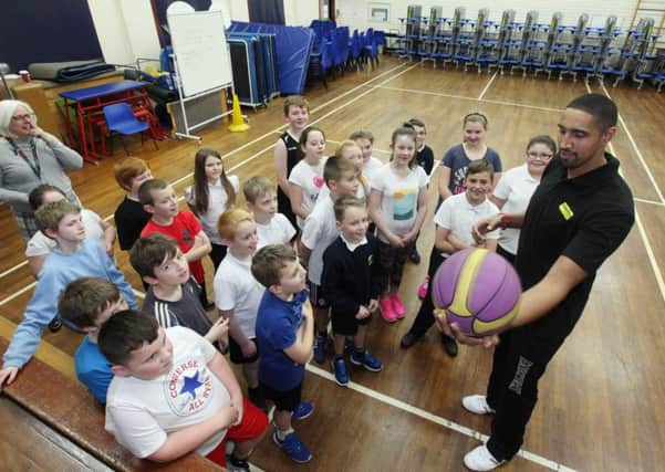 Kieron Achara, professional Team GB basketball player, talks to children at the event launch