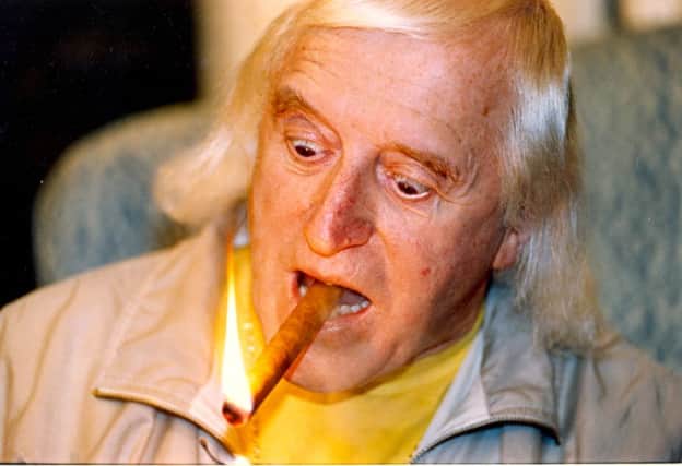 Jimmy Savile smokes cigar