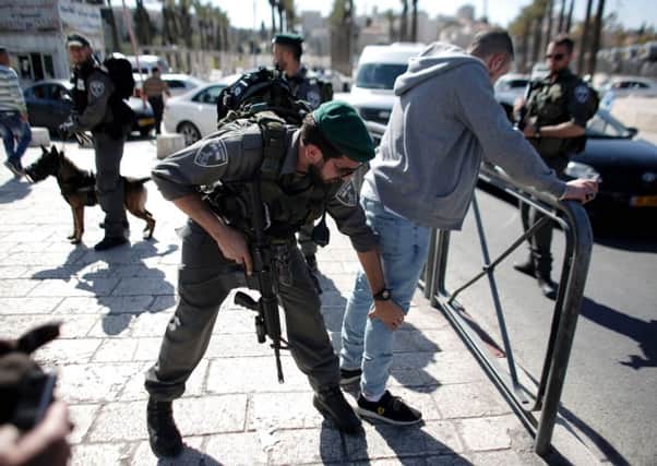 Israeli security forces pat down a Palestinian man atone of the main entrances to Jerusalem. Picture: AFP/Getty Images