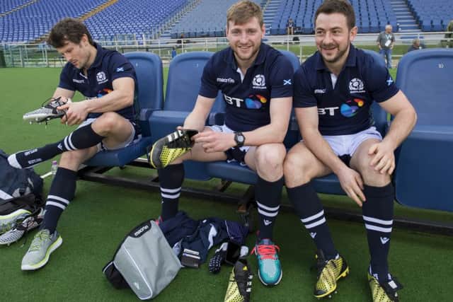Greig Laidlaw, right, puts on his boots before kicking practice in the
Stadio Olimpico with Peter Horne, left, and Finn Russell. Picture: Ian Rutherford
