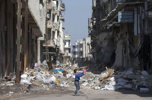 A boy plays among the rubble in Homs. Picture: AP/Hassan Ammar