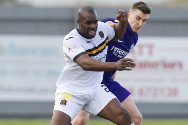 Dumbarton's Christian Nade (left) holds off Paul Hanlon. Picture: SNS