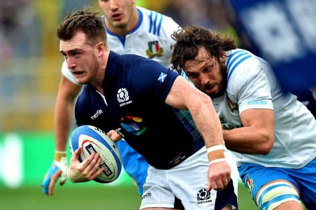 Full-back Stuart Hogg tries to escape a tackle by Italys Valerio Bernabo. Picture: AFP/Getty