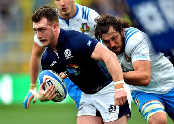 Full-back Stuart Hogg tries to escape a tackle by Italys Valerio Bernabo. Picture: AFP/Getty