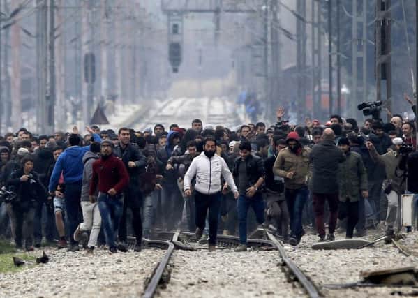 Stranded refugees and migrants in the northern Greek village of Idomeni approach the Greek-Macedonian border as they try to enter Macedonia. Pic AP