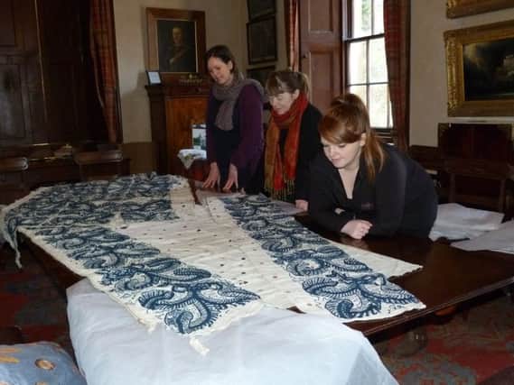 Dunollie project team members Jane Isaacson, left, Mary Freer, centre, and Gillian Campbell admire the ancient bed hanging. Picture: Moira Kerr