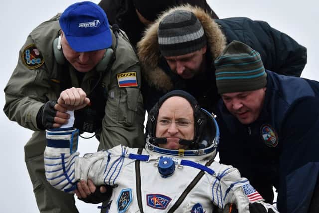 US astronaut Scott Kelly is helped off the Soyuz TMA-18M space capsule after 340 days in space. Picture: AP