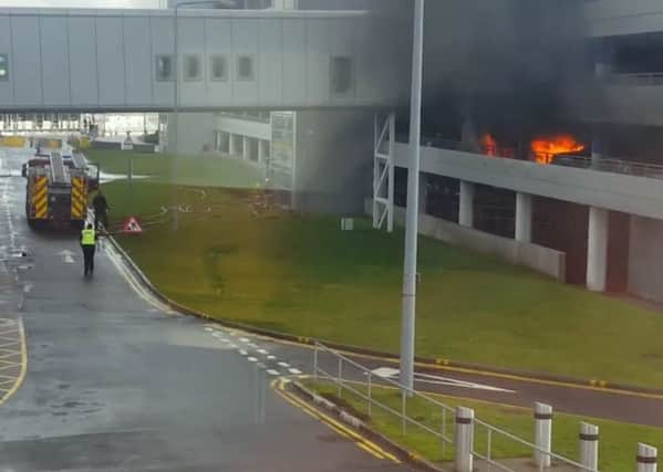 Firefighters at the airport after the Evoque went up in flames. Picture: Lisa Ferguson