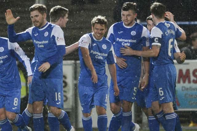 Andy Murdoch, centre, celebrates scoring the winner for Queen of the South against Hibs on Tuesday night. Picture: SNS