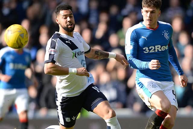 Dundee's Kane Hemmings is closed down by Rob Kiernan (right)