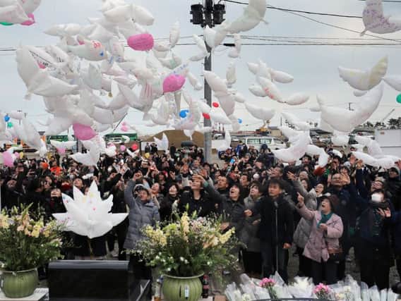 Dove-shaped balloons with messages for the victims of the tsunami are released in Natori, Miyagi prefecture yesterday. Picture: AFP/Getty Images