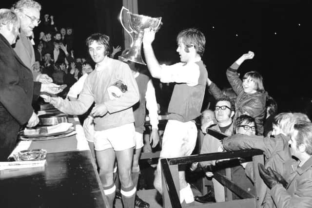 Hibernian captain Pat Stanton lifts aloft the League Cup after defeating Celtic 2-1 in the final at Hampden in December 1972. Second-half goals from Stanton and Jimmy ORourke  won the trophy for the first time in the Easter Road sides history. Picture: TSPL