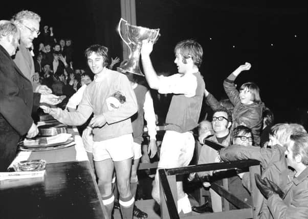 Hibernian captain Pat Stanton lifts aloft the League Cup after defeating Celtic 2-1 in the final at Hampden in December 1972. Second-half goals from Stanton and Jimmy ORourke  won the trophy for the first time in the Easter Road sides history. Picture: TSPL