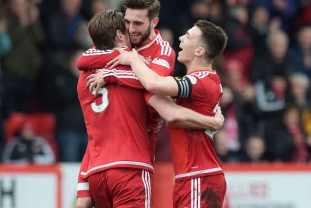 Ash Taylor is congratulated by team mates Graham Shinnie and Ryan Jack. Picture: SNS Group