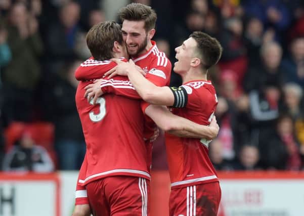 Ash Taylor is congratulated by team mates Graham Shinnie and Ryan Jack. Picture: SNS Group