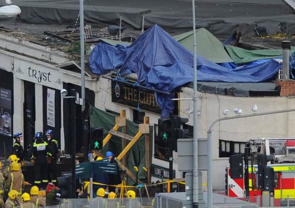 Tarpaulins cover the wreckage of the Police Scotland helicopter which plunged through the roof of the Clutha Bar in Glasgow. Picture: Robert Perry