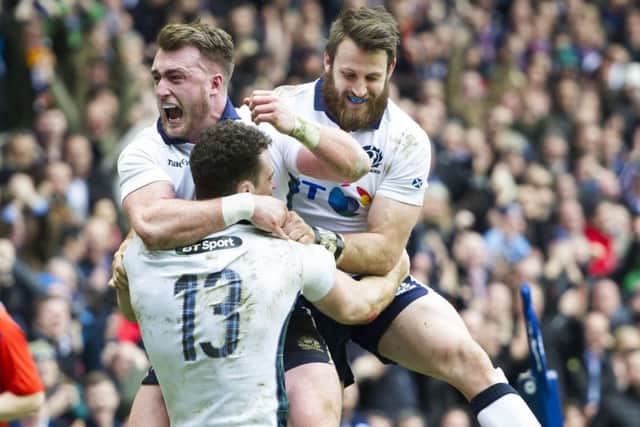 Scotlands Duncan Taylor (13) celebrates with Stuart Hogg, left, and Tommy Seymour after scoring. Picture Ian Rutherford