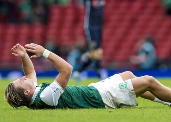 Jason Cummings lies prostrate on the Hamdpen turf hardly able to believe Hibs have lost the game
