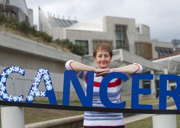 Breast cancer survivor Janet Brodie is urging the public to join the fight by adding a Saltire sticker to a giant structure of the word 'cancer'. Picture: Lesley Martin