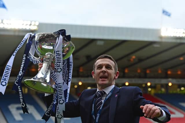 Ross County manager Jim McIntyre lifts the League Cup trophy after his side defeated Hibernian 2-1. Picture: Getty