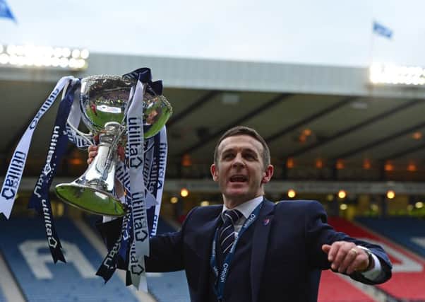 Ross County manager Jim McIntyre lifts the League Cup trophy after his side defeated Hibernian 2-1. Picture: Getty
