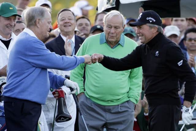 Arnold Palmer, centre, watches as Jack Nicklaus, left, and Gary Player touch fists after Palmer hit his ceremonial drive on the first tee before the 2014 Masters. Palmer will not be hitting the  tee shot this year. Picture: David J Phillip/AP