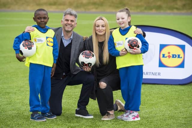 Former Scotland players Darren Jackson and Suzanne Grant join Lasine Diaby, left, and Lexi Henderson from St Annes Primary to celebrate Lidls partnership with the SFA. Picture: SNS