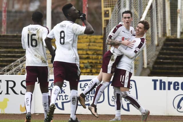 Jamie Walker (second from right) and Arnaud Djoum (left) played key roles in Hearts' victory over Dundee. Picture: SNS