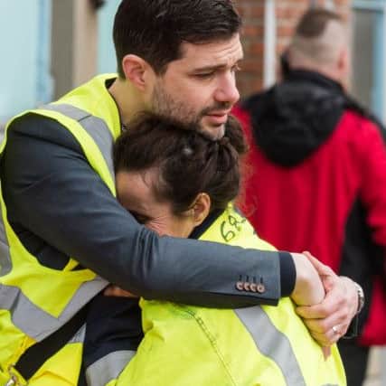 Two workers comfort each other outside Brussels Airport following the explosions. Picture: AP