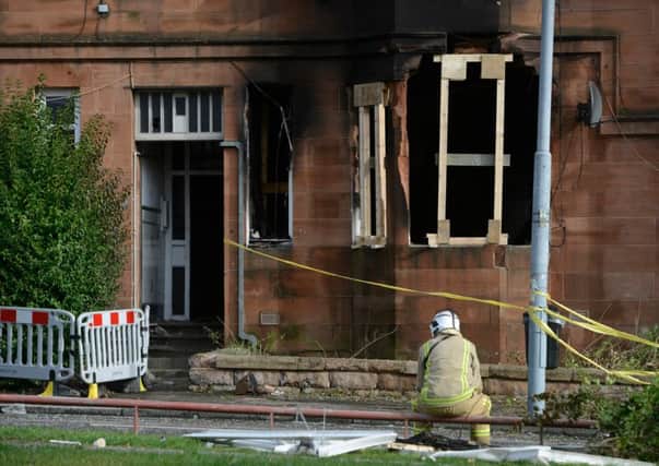 A firefighter surveys the damage to the flat. Picture: Hemedia