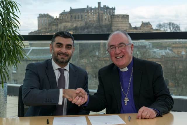 Omar Shaikh of the Islamic Finance Council UK and Rev Dr Angus Morrison sign the agreement in Edinburgh. Picture: Andrew O'Brien