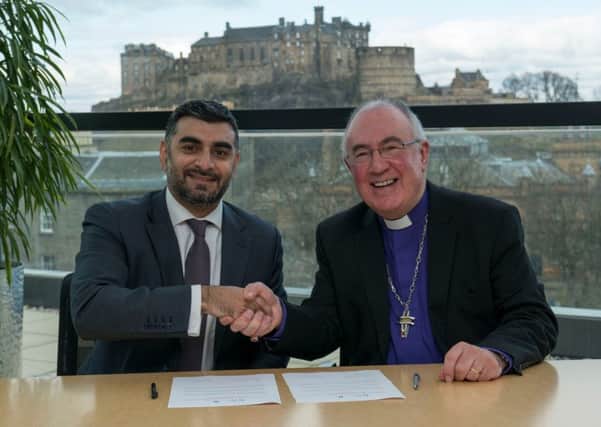 Omar Shaikh of the Islamic Finance Council UK and Rev Dr Angus Morrison sign the agreement in Edinburgh. Picture: Andrew O'Brien