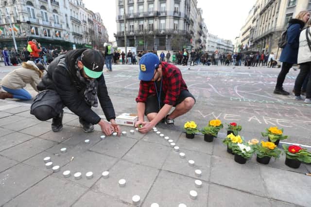 People leave candles and flowers in tribute to the victims outside Brussels stock exchange. Picture: AFP/Getty Images