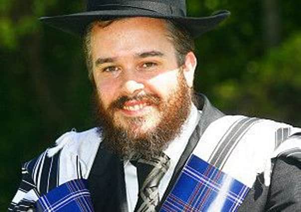 Rabbi Mendel Jacobs with a prayer shawl in the new Jewish tartan