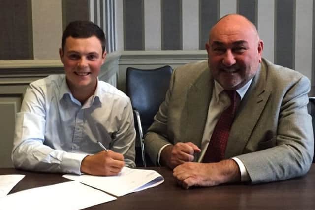 Jack McDonald puts pen to paper in Glasgow today watched by Andrew 'Chubby' Chandler