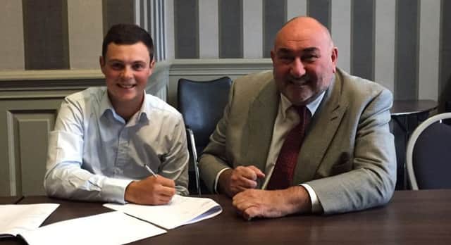 Jack McDonald puts pen to paper in Glasgow today watched by Andrew 'Chubby' Chandler