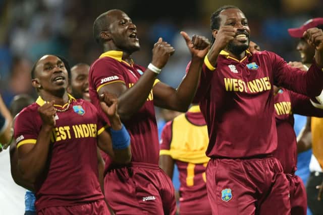 West Indies captain Darren Sammy, centre, Dwayne Bravo, left, and Chris Gayle celebrate after their victory over hosts India in the World T20 semi-final in Mumbai. Picture: AFP/Getty