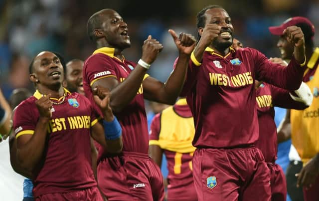 West Indies captain Darren Sammy, centre, Dwayne Bravo, left, and Chris Gayle celebrate after their victory over hosts India in the World T20 semi-final in Mumbai. Picture: AFP/Getty