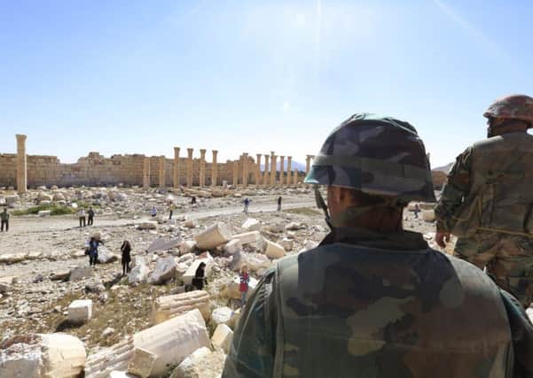 Soldiers look over damage at the historical Bel Temple in the ancient city of Palmyra. Picture: AP