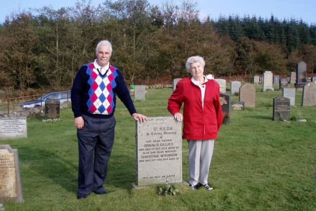 Former St Kilda resident Rachel Johnson with her son Ronnie at the grave of her parents Donald and Cristina Gillies.