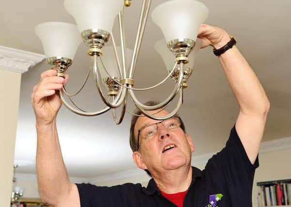 Volunteer James Summers fixes a lighting unit at a service user's home. Picture: Colin Hattersley