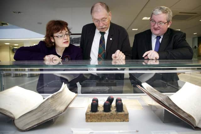 MSPs Sarah Boyack, Rob Gibson, centre, and Angus MacDonald, view copies of the first Register of Sasines, the first official register of property in the world, in Edinburgh in 2015. Photograph: Andrew Cowan