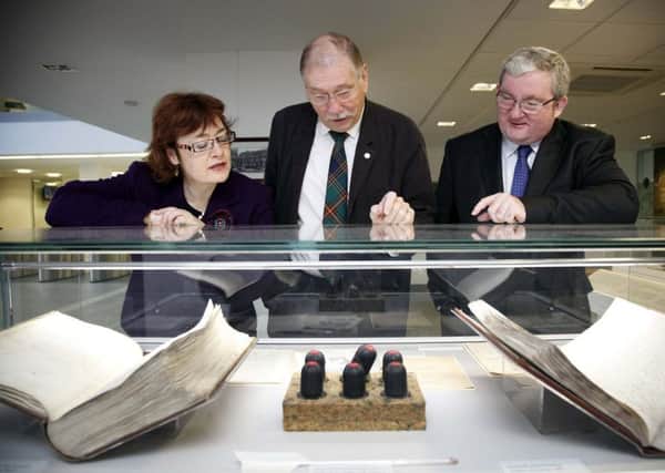 MSPs Sarah Boyack, Rob Gibson, centre, and Angus MacDonald, view copies of the first Register of Sasines, the first official register of property in the world, in Edinburgh in 2015. Photograph: Andrew Cowan