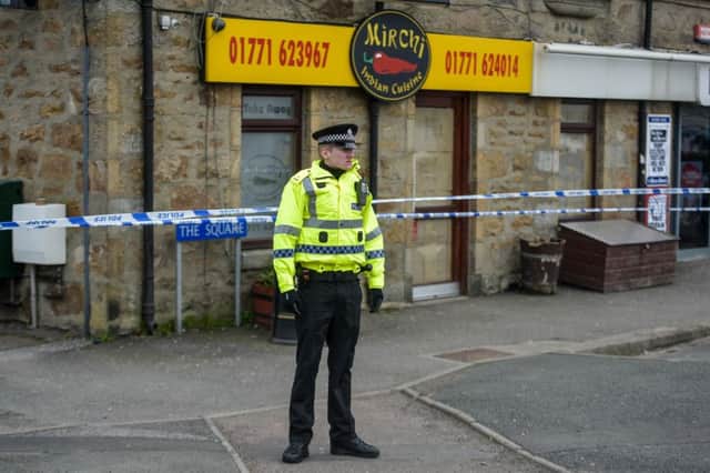 A Police Officer stands outside Mirchi Indian Cuisine in Mintlaw, Aberdeenshire