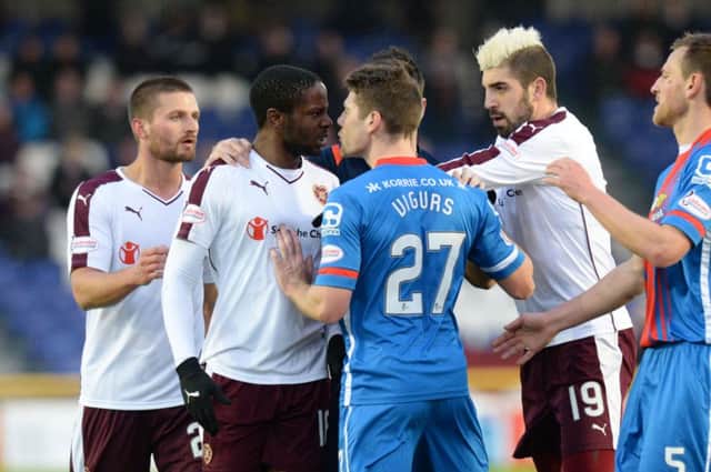 Hearts' Arnaud Djoum (left) clashes with Iain Vigurs. Picture: SNS