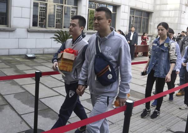 Sun Wenlin, left, and his partner Hu Mingliang hold hands as they arrive at the Furong District Court in Changsha in Hunan province. Picture: AP