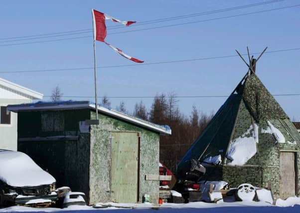 A tattered Canadian flag flies over a building in Attawapiskat, an indigenous area of Ontario, Canada. Picture: AP
