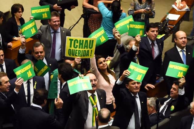 Deputies hold signs reading "Impeachment now" and "Bye darling" during a session in the lower house of the Brazilian Congress in Brasilia. Picture: Getty Images