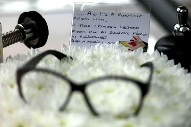 A pair of glasses rest on flowers at the funeral service of Ronnie Corbett. Picture PA